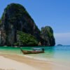 A boat sits at anchor in front of one of the famous karsts (rock formations) near Phra Nang Beach in Krabi, Thailand.